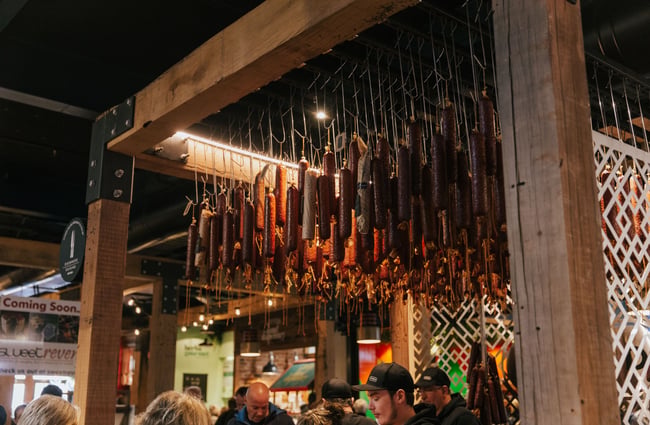 Hanging salami on a wooden frame.