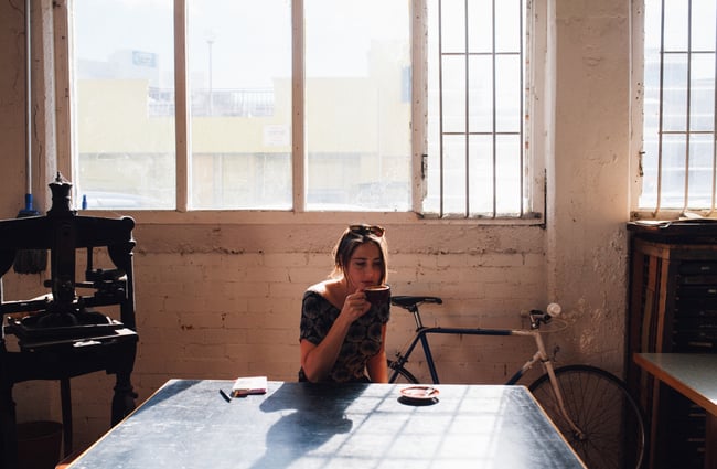 Woman drinking coffee in sunshine.