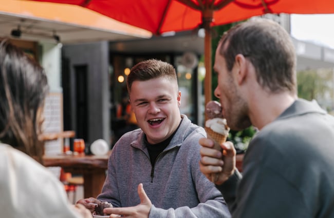 Man laughing while eating ice cream.
