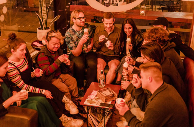 Group of people enjoying ice creams outside.