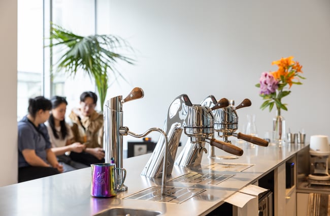 Silver under counter coffee taps on a blue tiled counter at Rook.