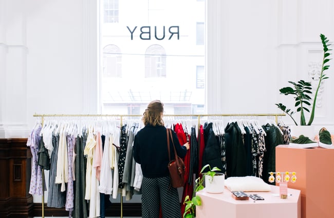 A woman searching through racks at RUBY, Wellington.