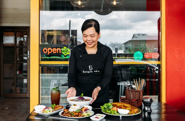 Wait staff putting food down on the table at Saigon '60s.