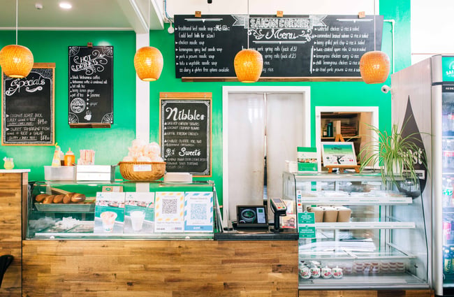 The wooden counter in front of the bright green wall.