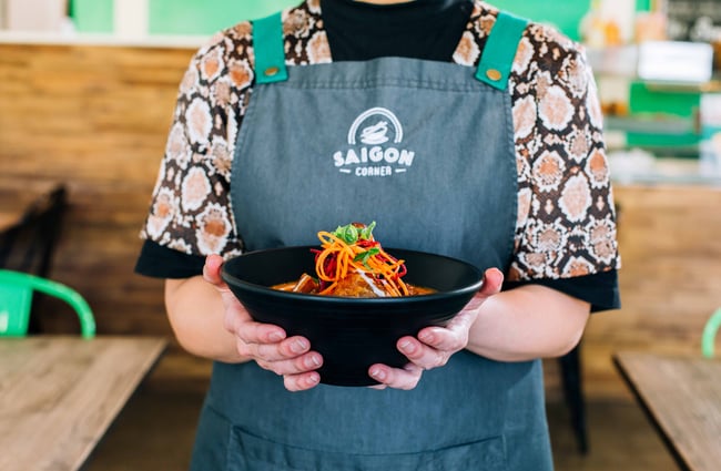 A staff member holding a bowl of food.