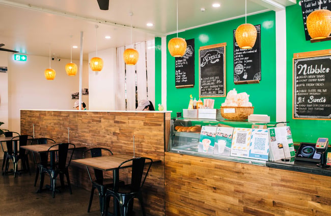 The counter inside the restaurant with a bright green wall.