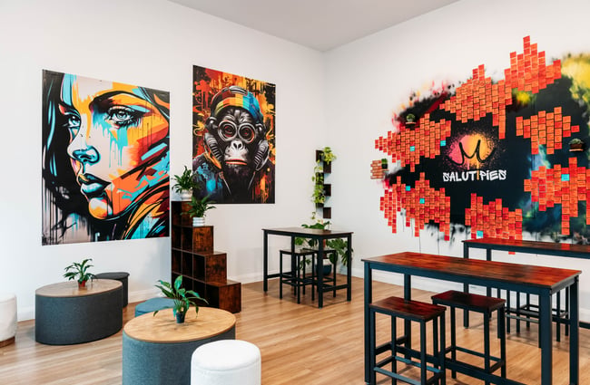 Artwork on the walls, table and chairs and board with post-it notes displaying pie flavours at Salut Pies.