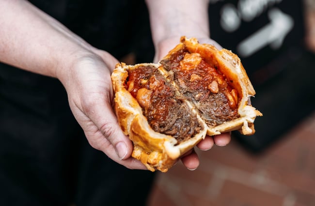 Pie cut in half being held by a customer at Salut Pies.