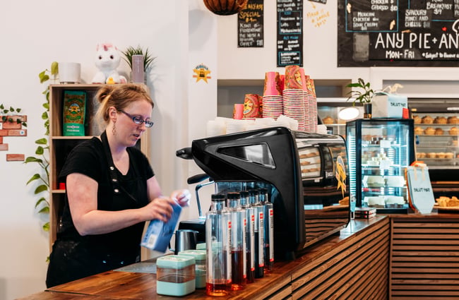 Barista behind the coffee machine at Salut Pies.