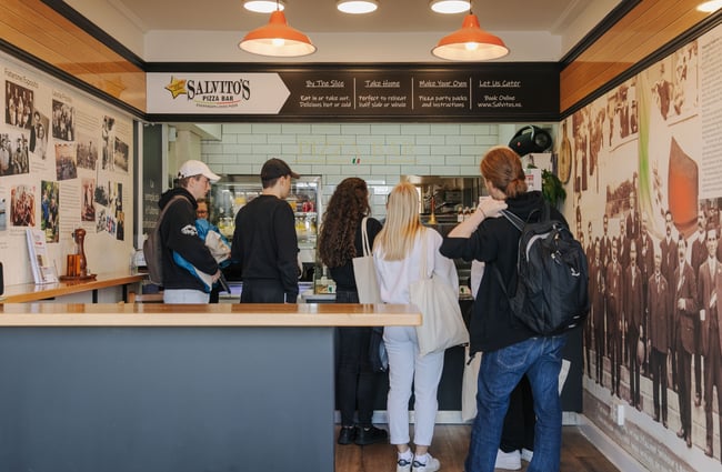 A group of teenagers inside the small Salvito's Pizza Bar.