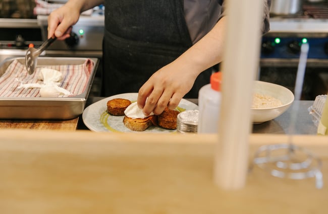 Chef preparing eggs benedict.