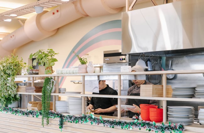 Two chefs standing at the pass.