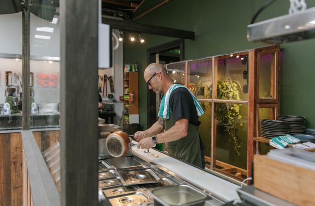 A chef working in a kitchen at Scoundrel cafe in Christchurch.