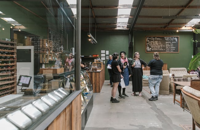 Customers standing about chatting in a cafe.