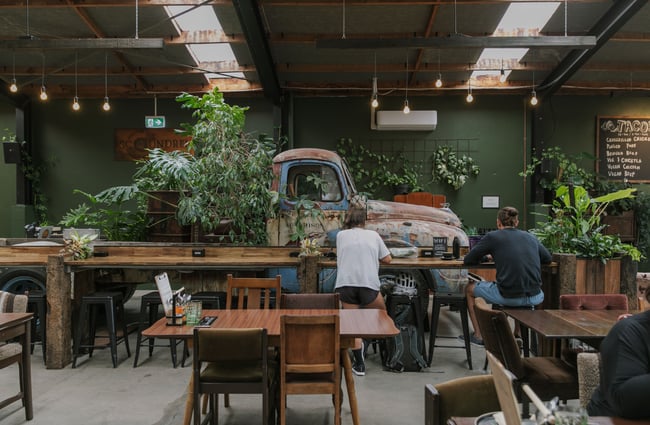 A large car in the middle of a cafe.