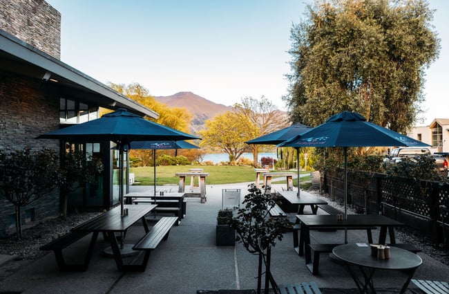 View of Scroggin's courtyard dining area with a view down to Lake Wānaka.