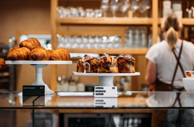 Croissants and cinnamon scrolls on stands on the counter at Scroggin, Wānaka.