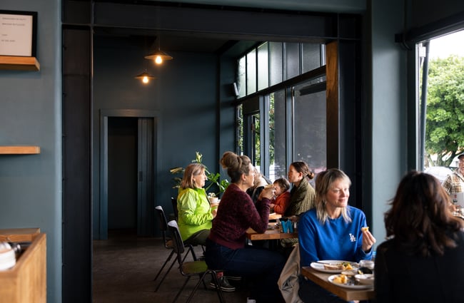 Customers dining at tables inside Seabreeze Auckland.