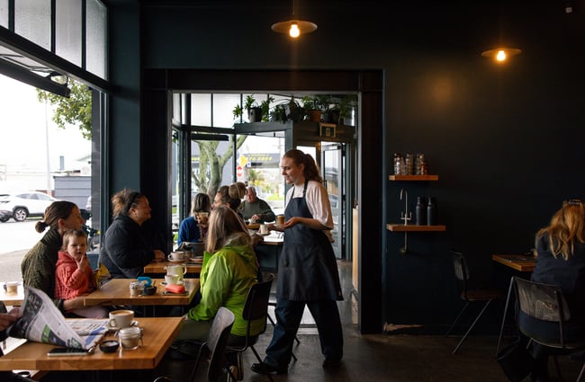 Customers dining at tables inside Seabreeze Auckland.