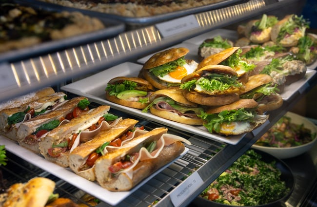 A close up of filled rolls in a glass cabinet.