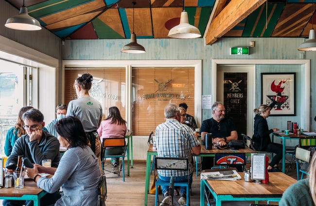 People dining inside Seashore Cabaret next to the open doors to the deck area.
