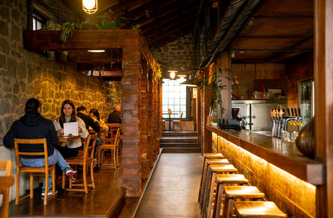 The yellow lit restaurant and bar interior of Sen Kitchen in Auckland.