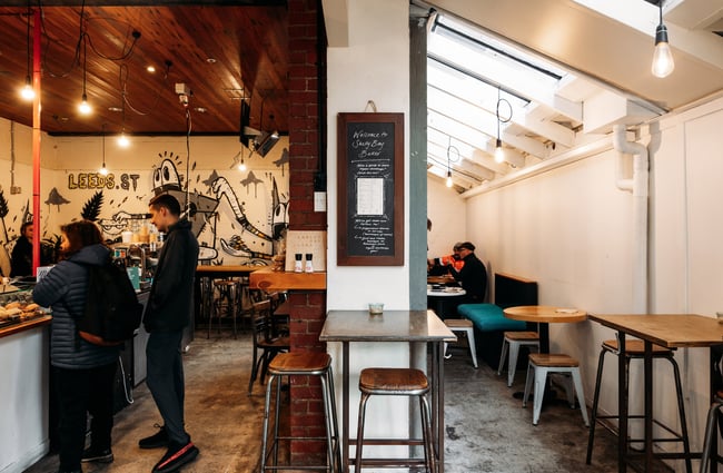 Interior of Shelly Bay Baker on Leeds Street with wall dividing customers ordering on one side and people sitting in the dining room on the other side