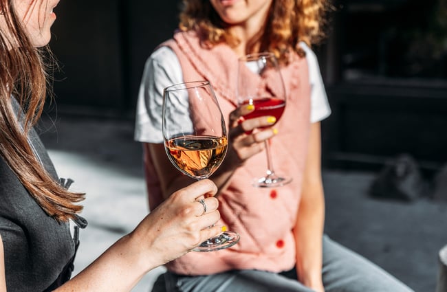 Two women holding glasses of wine.