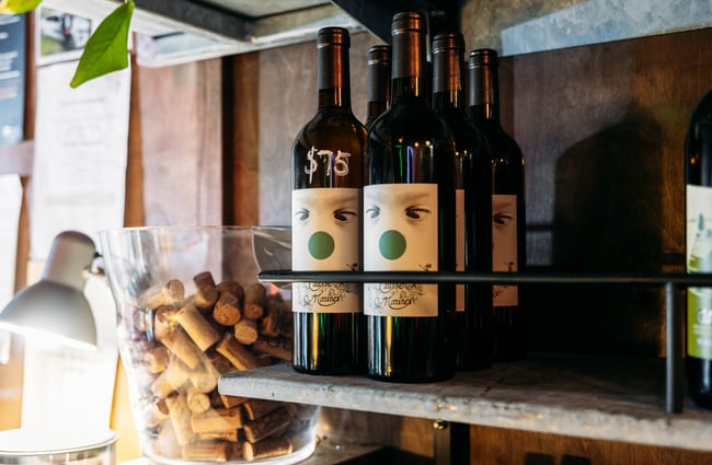 Two bottles of wine on display on a shelf.