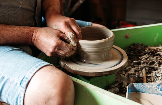 Close up of potter creating a ceramic bowl at the pottery wheel