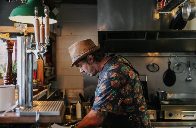 Chef standing behind the beer taps at Slam Club.