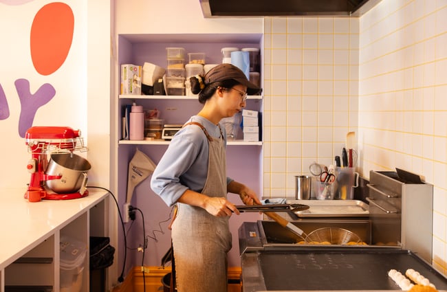 A woman cooking in a kitchen.