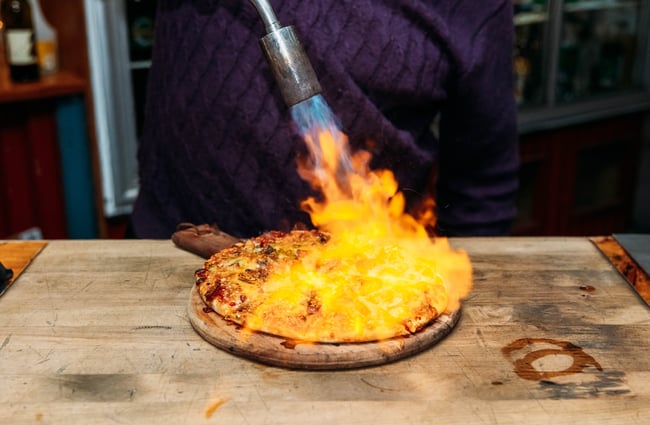Flames on a pizza before it is served.
