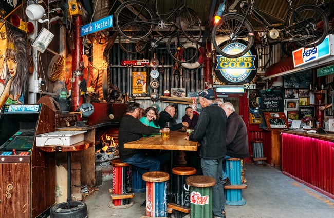 A group of men sitting around a high table in a pub.
