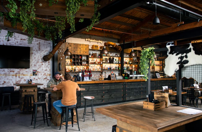 Two people dining inside a cool and modern bar space.