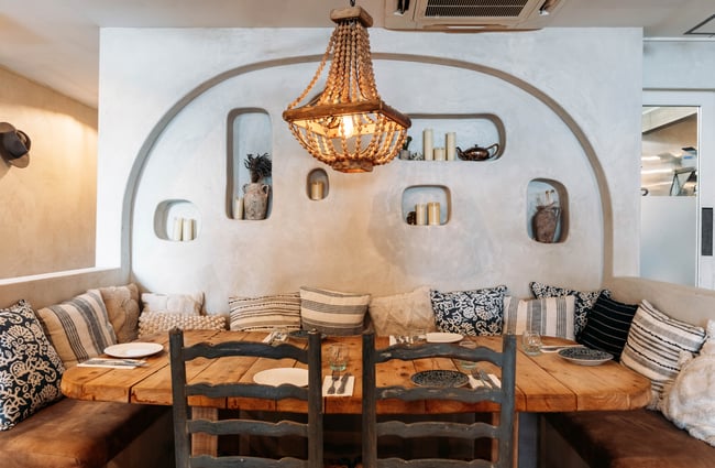 Booth seating with decorative lighting above the table at Sofi.