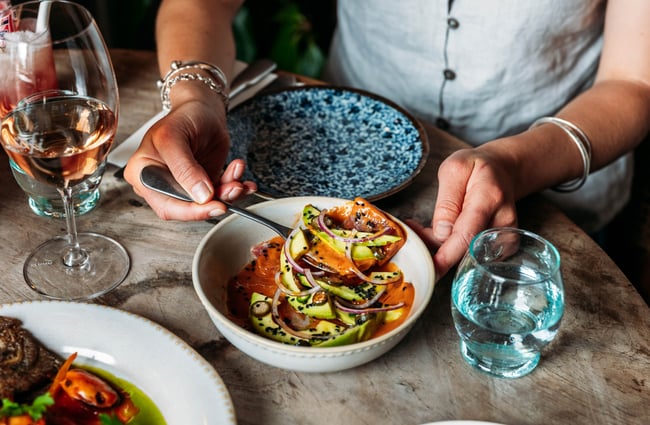 Customer dishing up from a food dish at Sofi.
