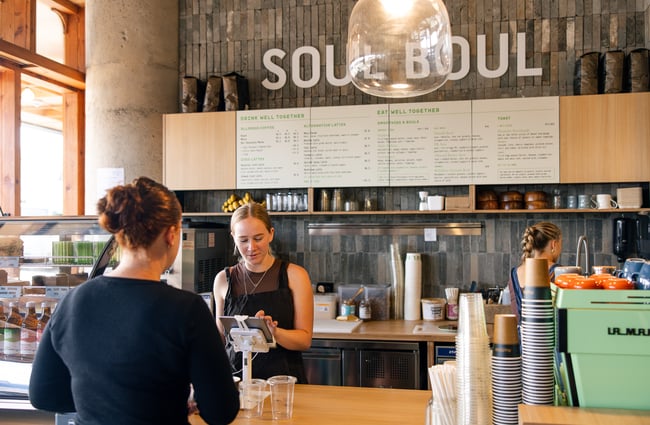 A staff member serving a customer at a cafe.