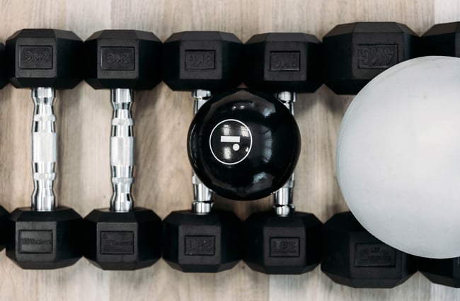 Dumbells and balls lined up on the ground at Soul Pilates.