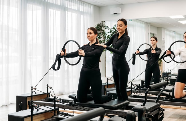 Instructor assisting a client on the reformer machine at Soul Pilates.
