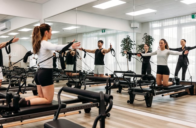 A number of clients participating in a reformer class at Soul Pilates.