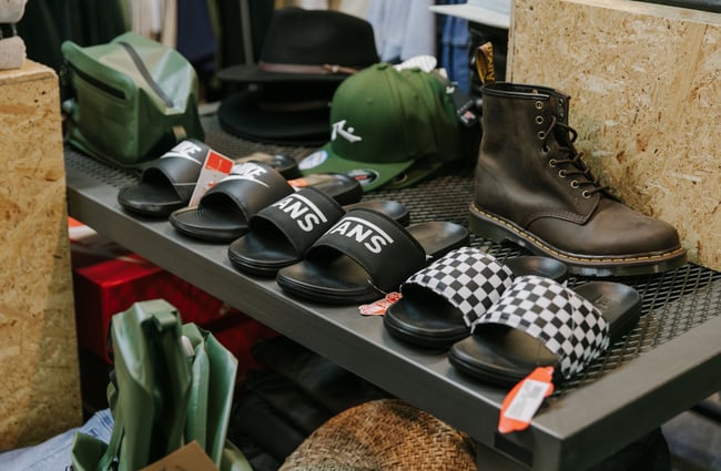 A close up of shoes and sandals on a low table.