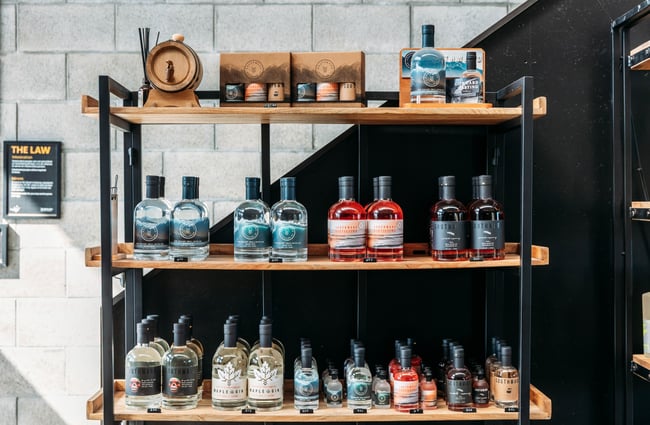 A close up of bottles of gin on shelves.