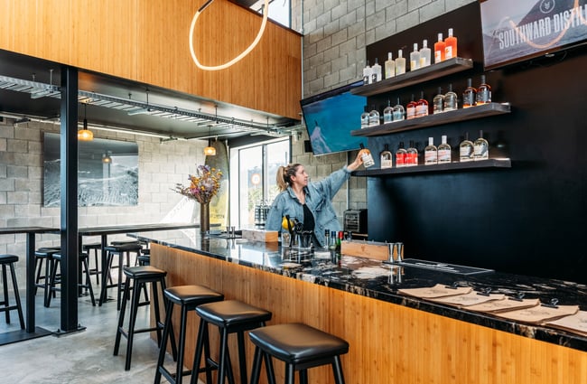 A woman behind a bar.