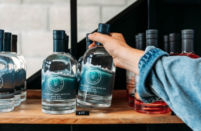 A hand holding a gin bottle.