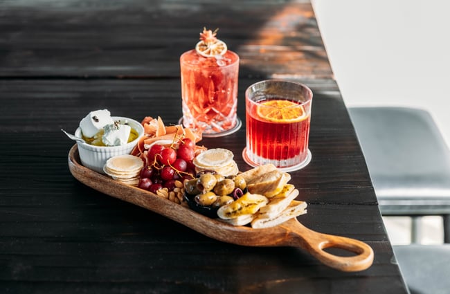 A platter and cocktails on a table.