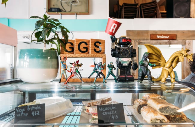Glass cabinet of savoury goods with figurines on top.