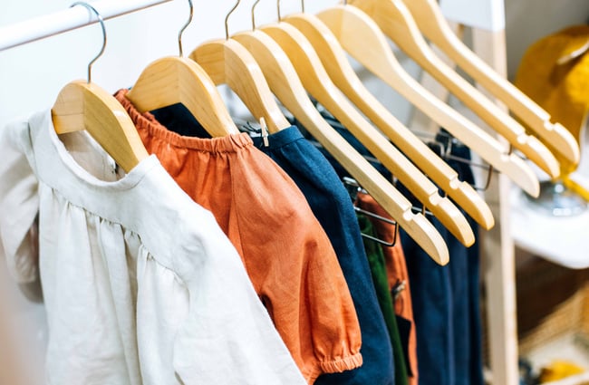 Close up of clothes on wooden hangers.