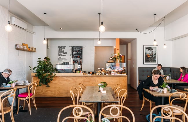 Customers dining inside the brightly lit Squirrel cafe in Wellington.