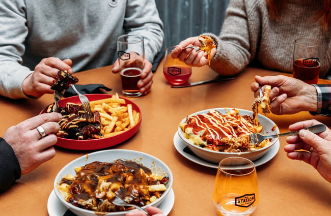 A group of people eating plates of food.